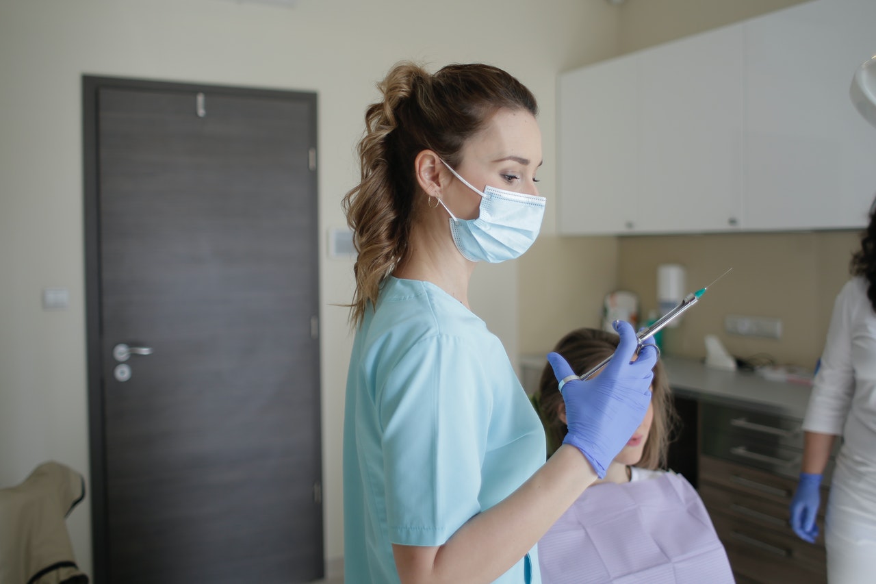 woman-in-teal-scrub-suit-holding-injection